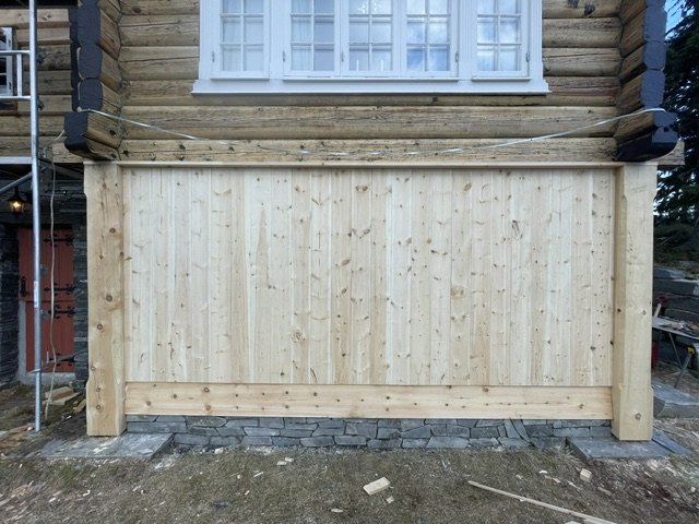 Ny liggende furukledning på laftet hus, med skifermur under