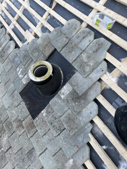 Skifertak under legging rundt pipegjennomføring